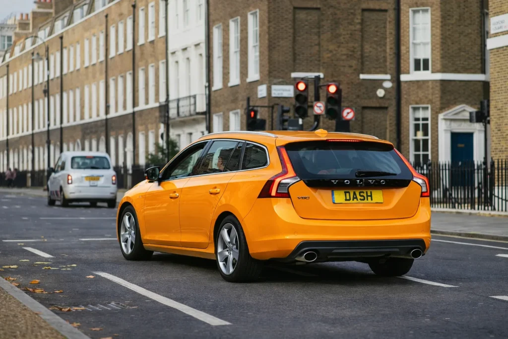 Orange Volvo with DASH registration at traffic light